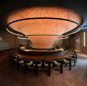 Circular restaurant space with brick ceiling and walls, featuring a central dining area and modern seating.