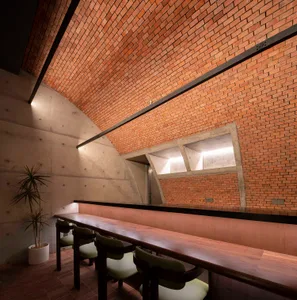 Modern brick bar with concrete interior and seating area.