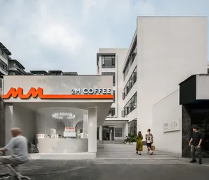 Coffee shop exterior with minimalist design featuring white construction and contemporary aesthetic.