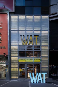 A modern storefront with large glass windows displaying illuminated signage