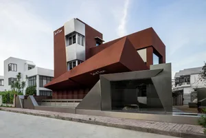 Modern house featuring metallic, glass, and concrete exterior materials.