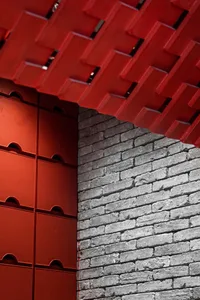 Modern restaurant interior with brick and concrete walls featuring red accents.