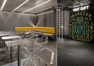 A modern restaurant interior with metallic tables and chairs, a yellow bench, and a neon sign that reads 'WAT GIFT CHANGSHA'.