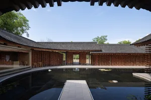 A modern architectural courtyard with wooden walls and a pond.