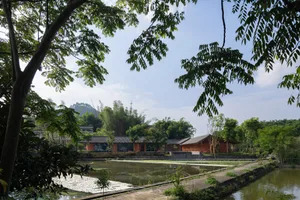 A serene village scene featuring natural elements and a pond.