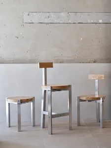 Steel and wooden stools and chairs with minimalist design in an industrial setting