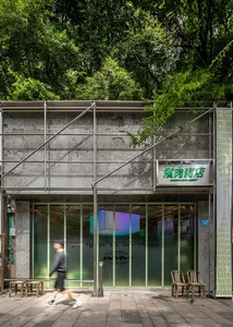A metal storefront with green glass panels and a green sign.