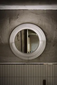Minimalist bathroom features polished concrete floor and white tiled walls.