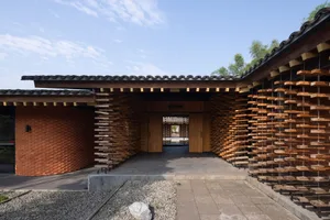 A modern hotel entrance featuring wooden walls and a tiled roof.