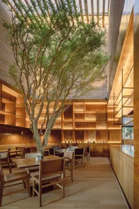 A modern restaurant interior with wood furniture and shelving.