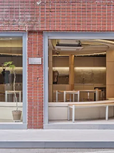 Minimalist storefront with brick facade and glass window.