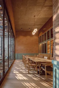 Modern restaurant dining room with wooden furniture and brick walls