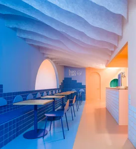 Modern restaurant interior with blue and orange plastic ceiling tiles and blue floor tiles.