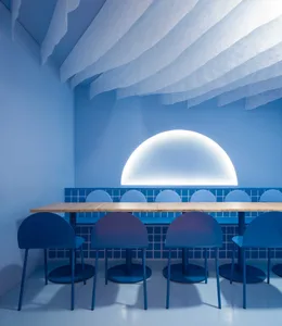 Blue minimalist restaurant interior with blue tables, chairs, and walls