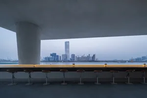 A minimalist modern bar featuring a view of a city skyline from a concrete interior