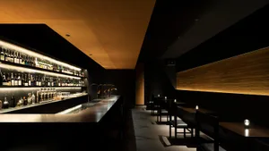 工業風餐廳室內，木質牆面、玻璃吧台與瓷磚吧區。