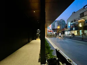 A bustling urban streetscape featuring concrete sidewalks and asphalt roads.