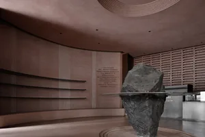 A minimalist installation featuring a black metal sculpture and shelves.