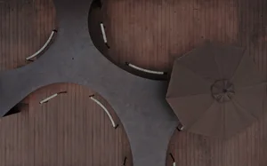 A modern outdoor lounge area featuring concrete seating and a large brown umbrella.