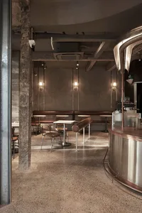 Concrete interior of an industrial-style coffee shop with minimalist design.