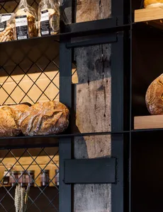An image showcasing a metal frame with a wooden panel in a bakery interior.
