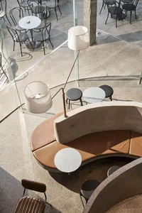 Industrial-style coffee shop interior with concrete, leather, and metal elements.