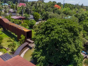 A modern metal bridge surrounded by lush greenery.