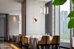 Modern restaurant interior with contemporary design elements and large windows overlooking urban landscape.