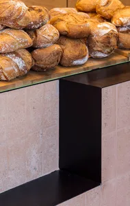 A bakery's bread counter showcasing rustic loaves of bread.