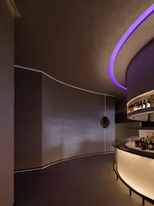 A modern bar with concrete walls illuminated by LED lighting