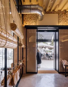 Industrial restaurant entrance with glass, concrete, and brick materials