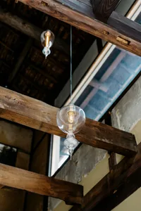Industrial lighting with glass bulbs and sockets hanging from wooden beams