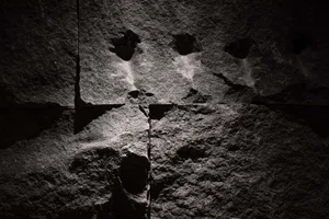 A textured stone wall covered with graffiti