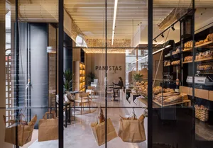Interior of a minimalist bakery with wooden features, showing clean lines, natural light, and an emphasis on simplicity and f