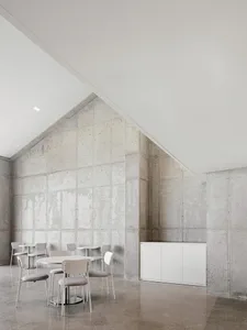 A modern interior space featuring a concrete wall and minimalist furniture.