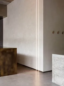 Modern interior design featuring concrete and brass elements.