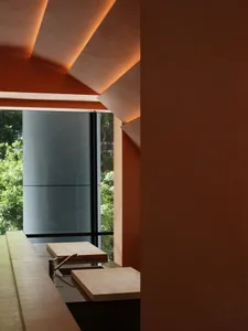 A modern kitchen interior featuring wooden countertops and concrete walls with ambient lighting