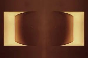 A symmetrical, modern light fixture with a warm, ambient glow.