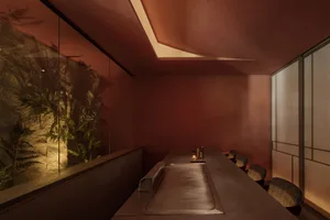 A minimalist restaurant interior featuring a brick counter and seating area.