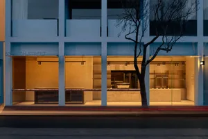 A modern retail storefront with a concrete facade and illuminated interior.