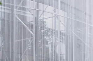 Scaffolding netting covering a construction site, providing safety and support structures.