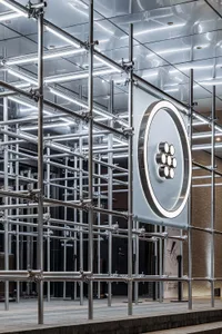 A modern, industrial installation featuring metal scaffolding and lighting elements.