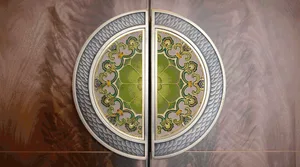 Metal circular ornament with intricate green glass mosaic