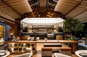 A well-lit, modern coffee shop with wooden accents, showcasing a variety of coffee-related items and a large glass window.