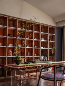 Modern living room with wooden furniture, indoor plants, and bookshelves.