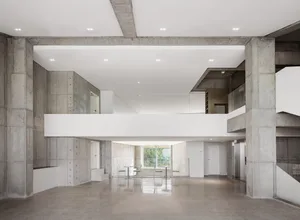 A modern lobby interior with concrete walls and ceiling, featuring a minimalist design.