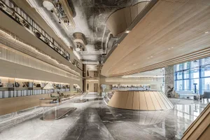 Modern lobby interior with marble flooring, wooden accents, and sophisticated lighting design.