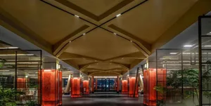 A modern office with glass walkways and red pillars.