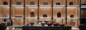 Tea room interior with wooden shelves and a tray holding various ceramic tea pots and cups.