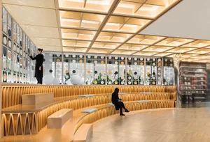 A modern library with a wooden display wall featuring a pattern of circular cutouts.